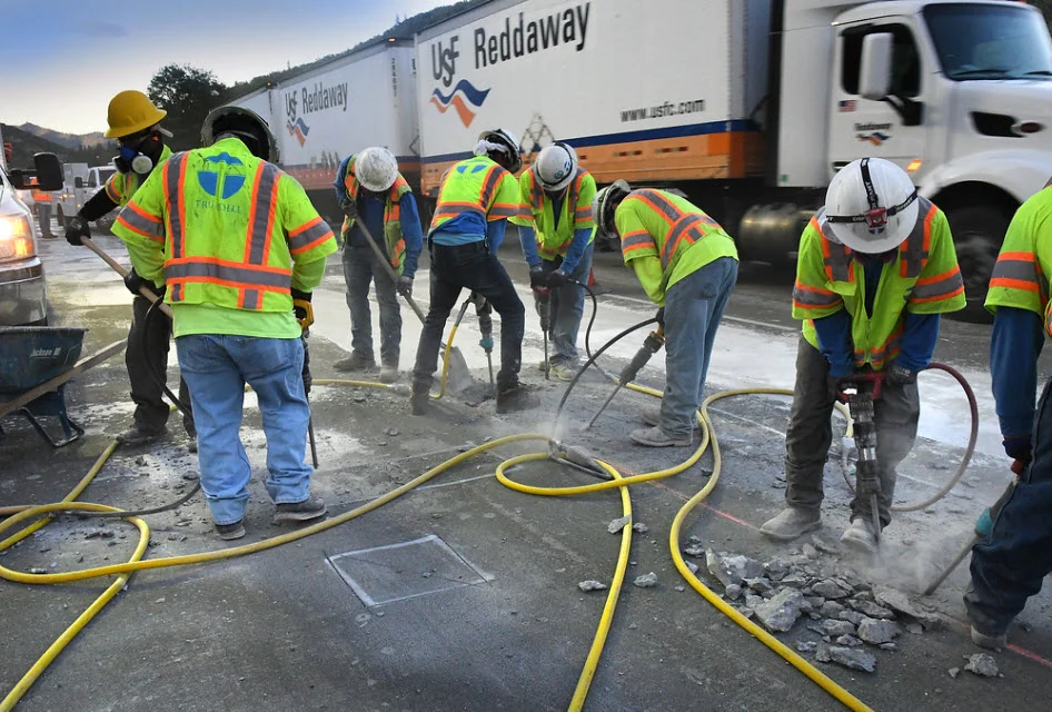A crew repairs the concrete deck of an I-5 bridge while traffic passes beside the work area in Oregon in 2020